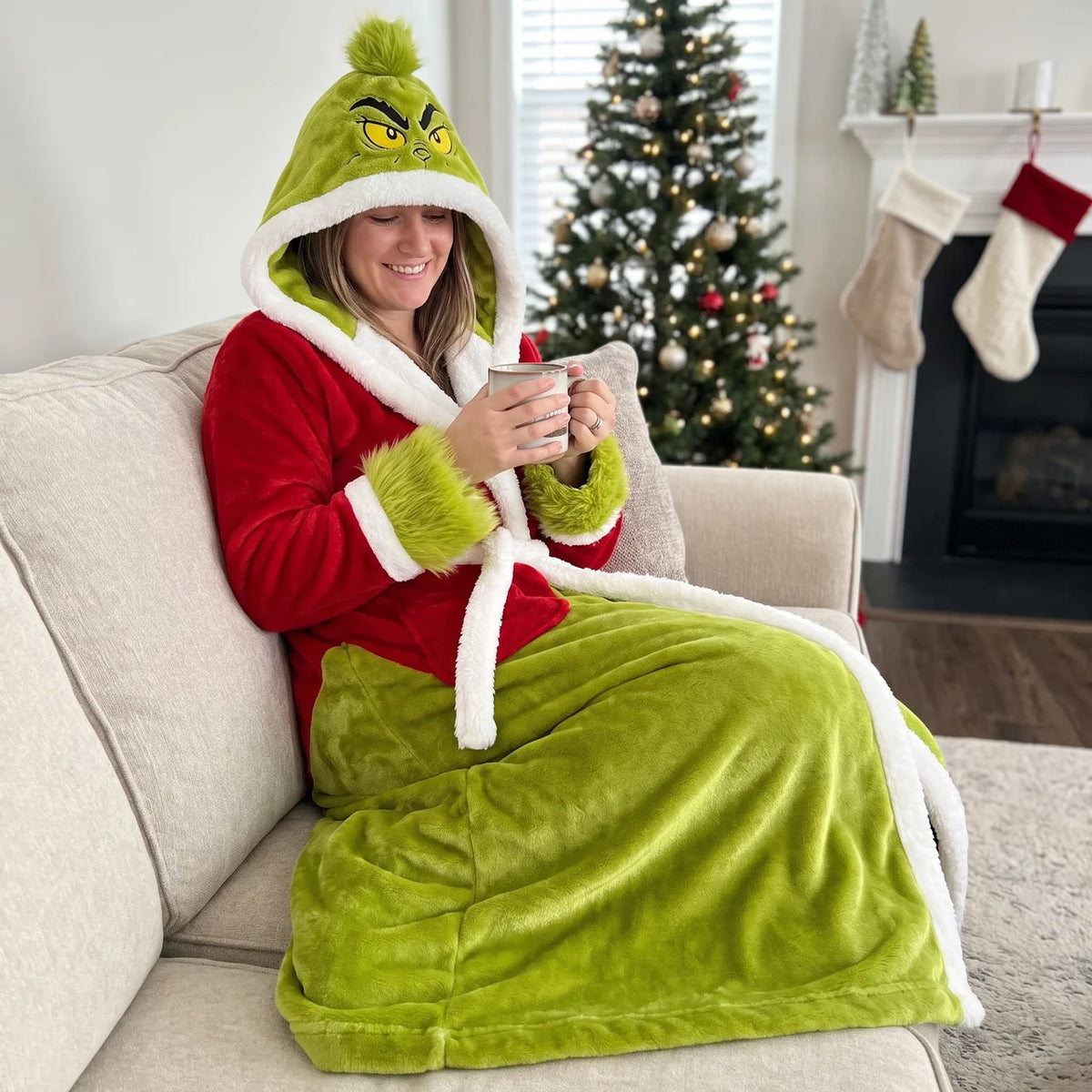 Woman wearing the hooded sherpa robe and holding a warm drink